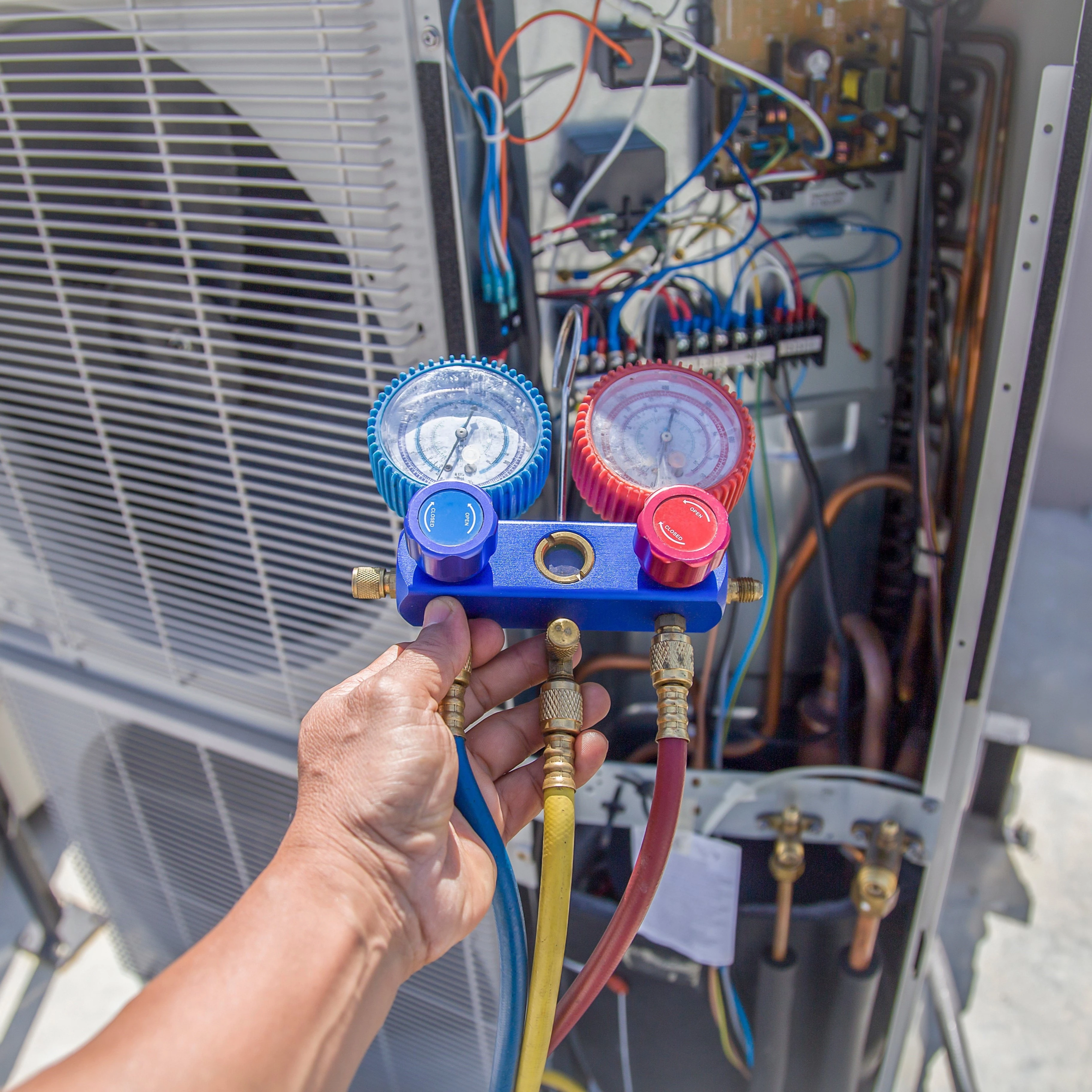 An Air Dynamics technician servicing an outdoor HVAC unit during an AC installation in Tulsa.